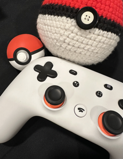 Photo of a stadia controller and two Pokeballs